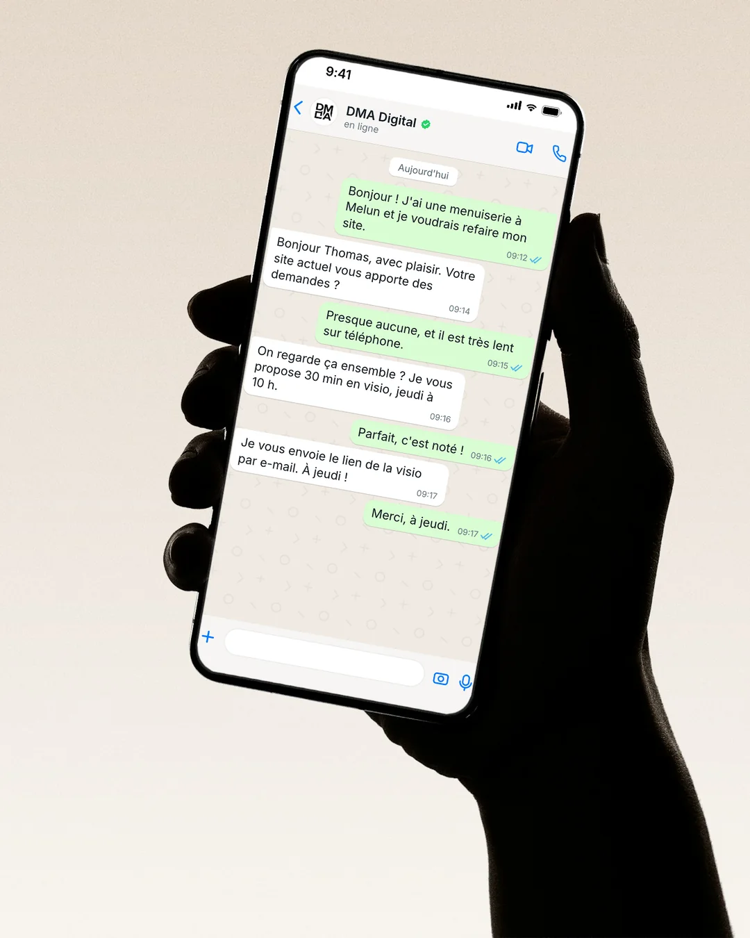 A hand holding a phone: a WhatsApp conversation with DMA Digital about rebuilding a website