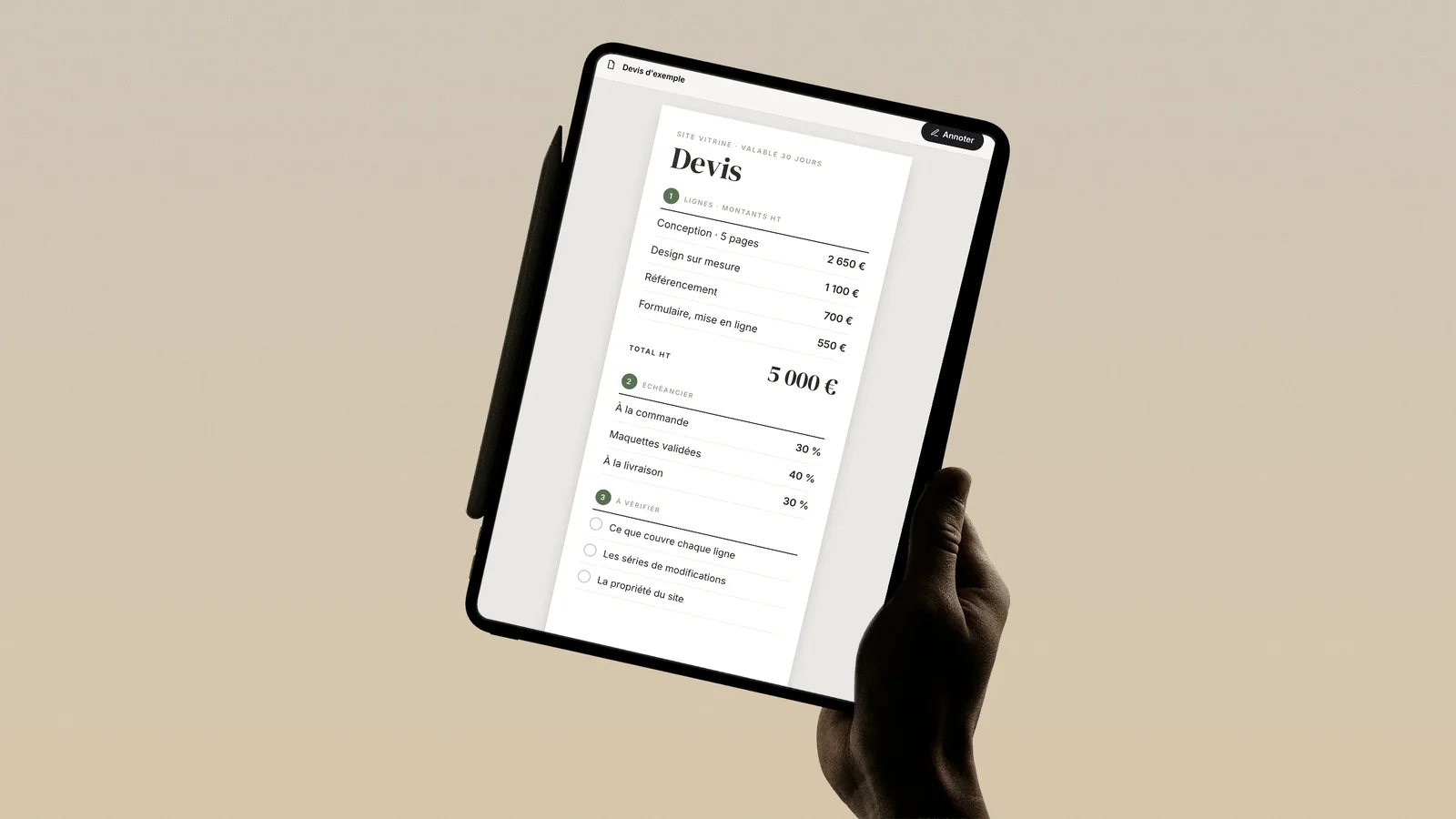 Devis de site vitrine annoté sur une tablette tenue en main : lignes, échéancier en trois versements et points à vérifier